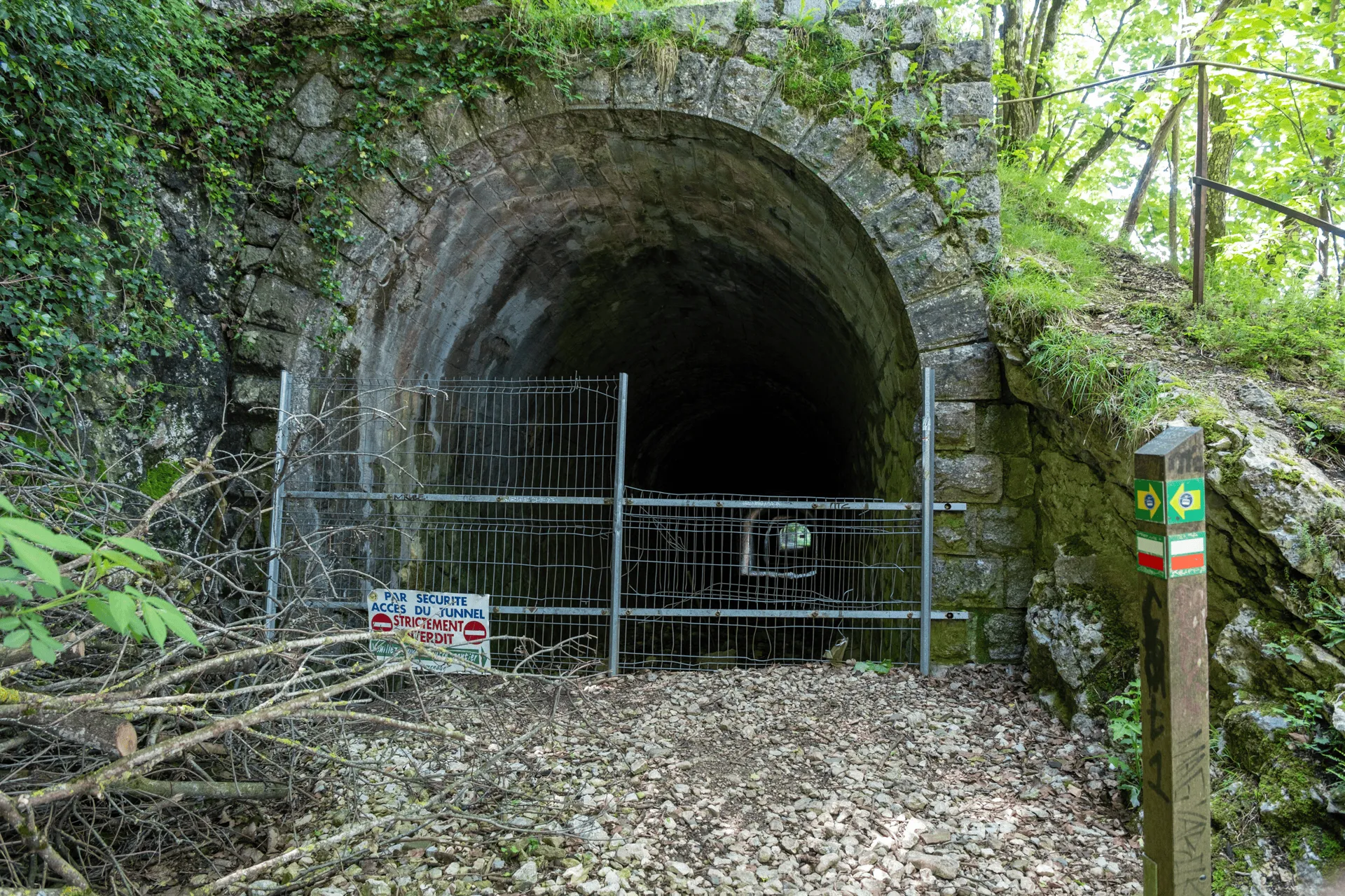 "A dark tunnel entrance blocked by a gate"