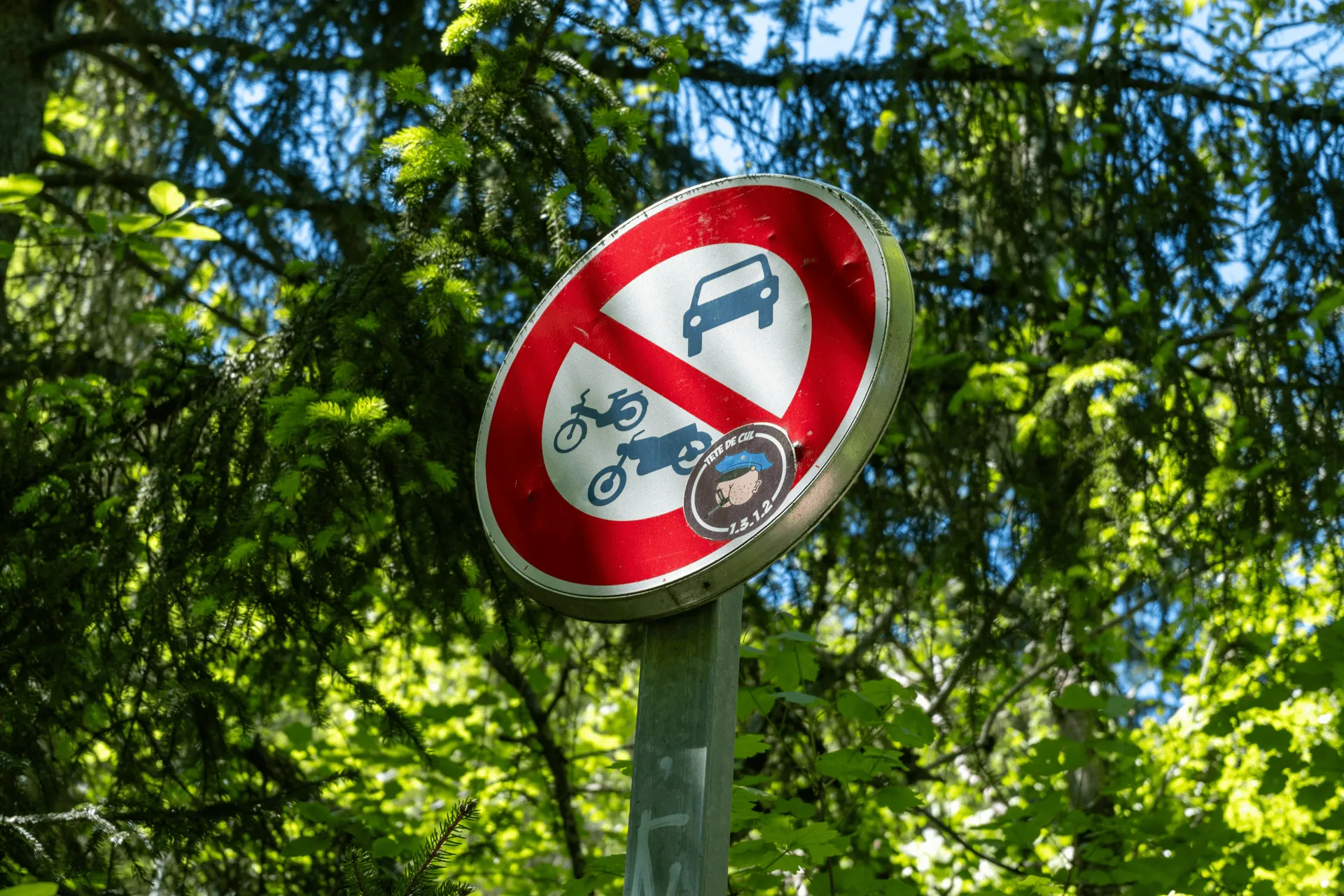 "A forbidden sign with a sticker showing a police officer"
