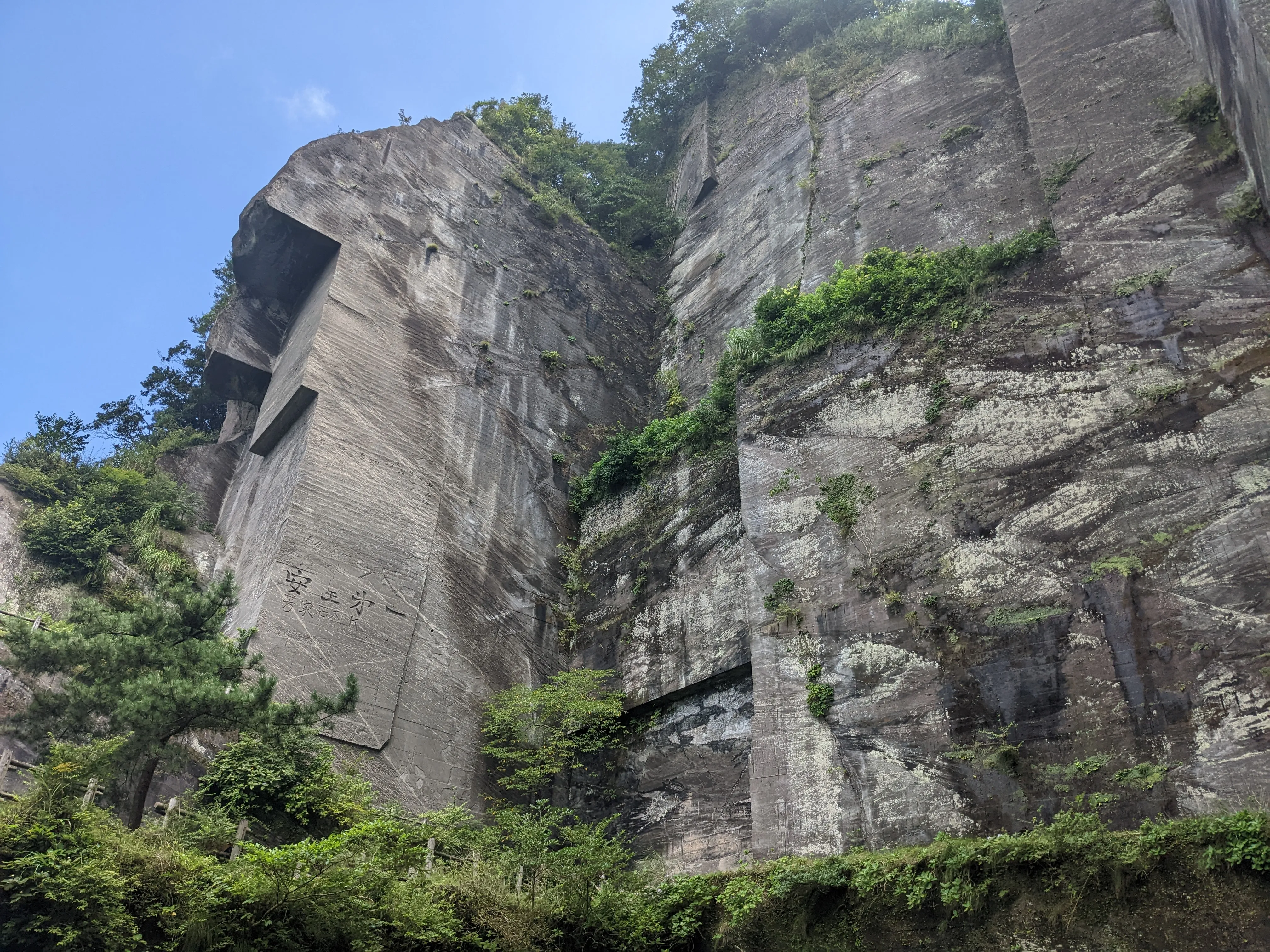 A huge rockface, with rectangular chunks carved out of it.