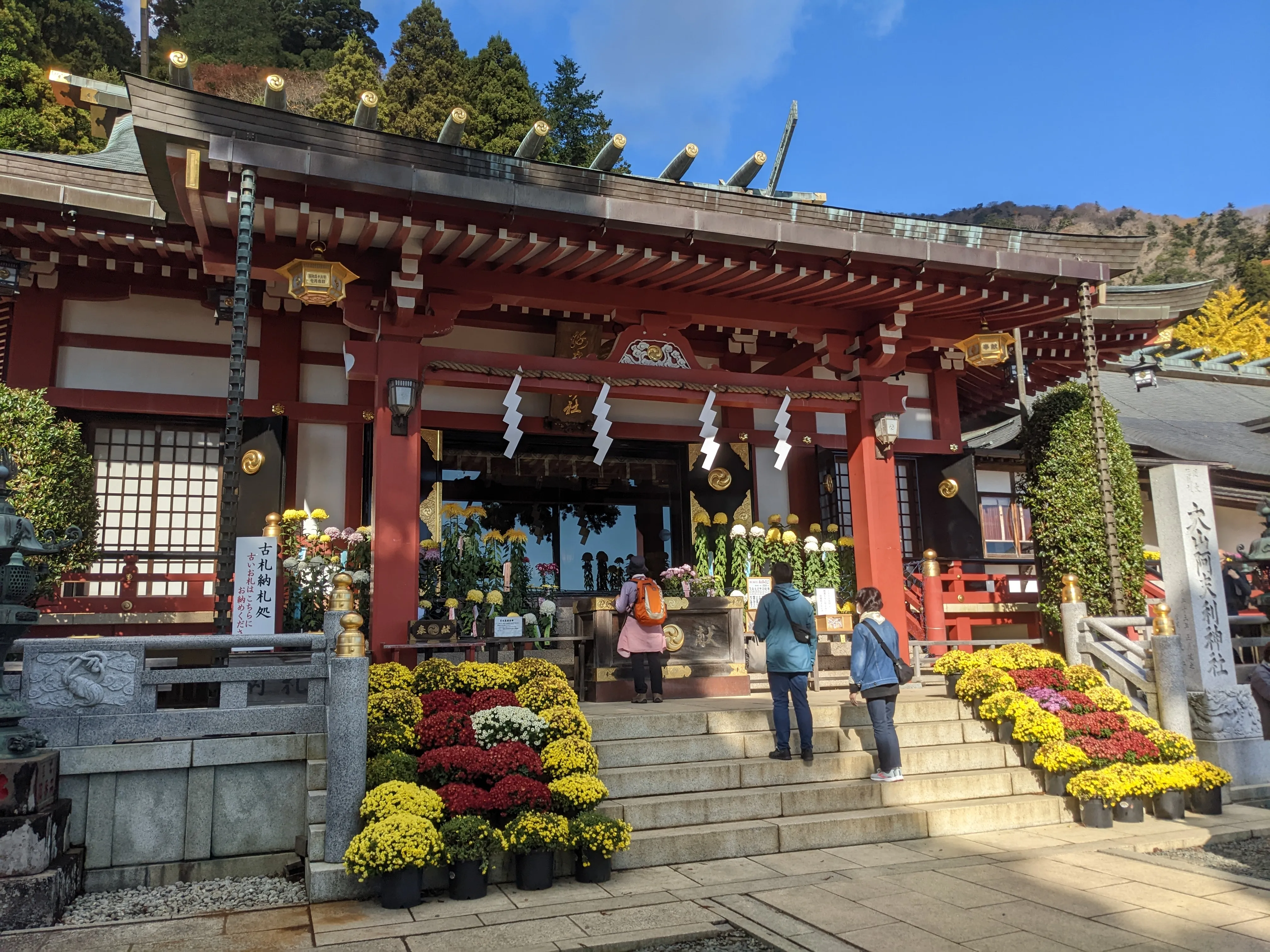 A red shrine with yellow flowers lining the small set of stairs up.